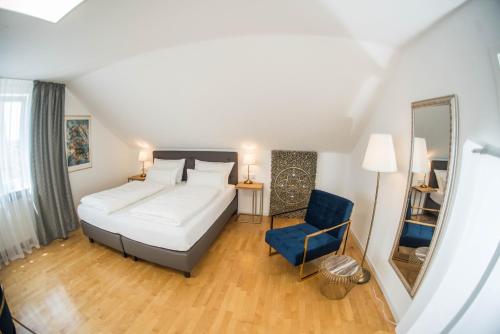 um quarto com uma cama grande e uma cadeira azul em City Apartments FN L7 KLIMATISIERT-mit Küche em Friedrichshafen