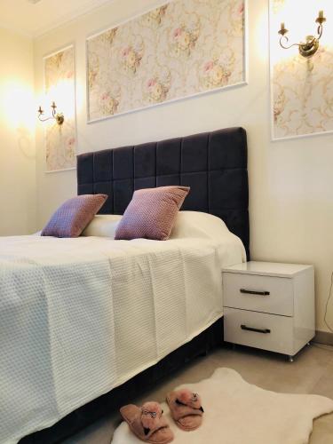 a bedroom with a bed with a black headboard at Zlatibor Hills Star Wellness & Spa in Zlatibor