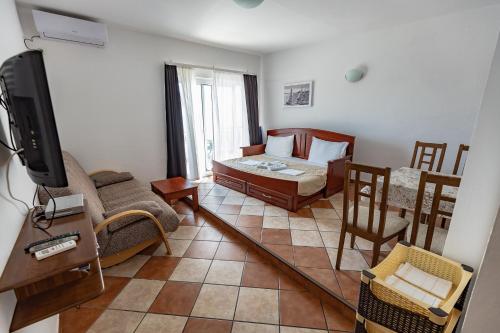a living room with a couch and a bed and a television at Adriatic Apartment in Ulcinj