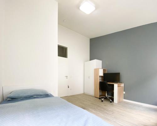 a bedroom with a bed and a desk at Traumhaftes Privatzimmer in Karlsruhe in Karlsruhe