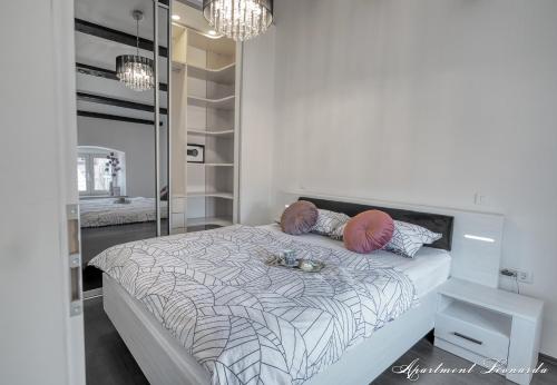 a white bedroom with a bed with a mirror at Penthouse Leonarda with private parking in Pula