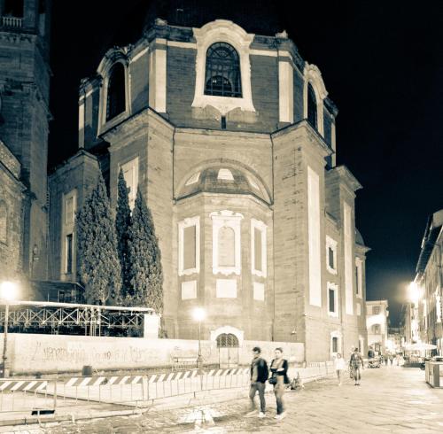 two people standing in front of a building at night at Solo Experience Hotel in Florence