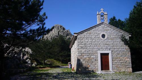 a small stone church with a cross on top at Vallicciola Nature Hotel in Tempio Pausania