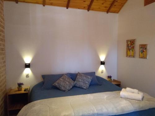 1 dormitorio con 1 cama azul y 2 lámparas en Chalés Lanelli, en Monte Verde