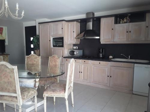 a kitchen with a glass table and chairs in it at Appartement rdc pieds dans l'eau in Sète
