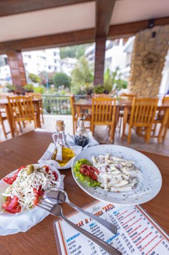 a wooden table with two plates of food on it at Adriatic Apartment in Ulcinj
