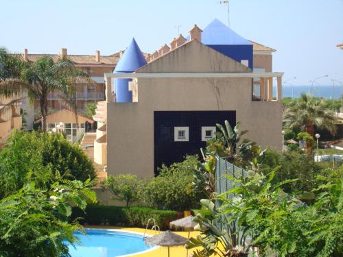 a house and a swimming pool in front of a house at Islantur Ipanema in Islantilla