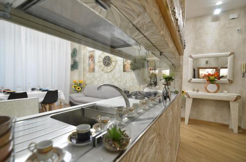 a kitchen with a sink and a living room at CASERTA DELUXE BIS in Caserta