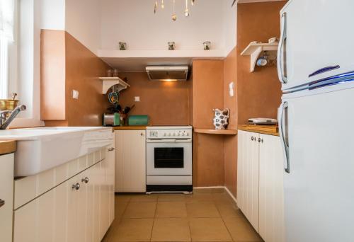 a kitchen with white cabinets and a white refrigerator at Casa Nostalgia in Adamas