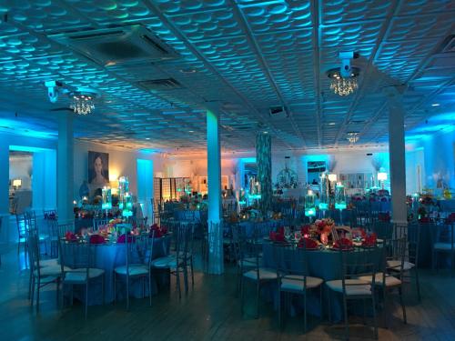 una stanza piena di tavoli e sedie con illuminazione blu di Long Beach Hotel a Long Beach