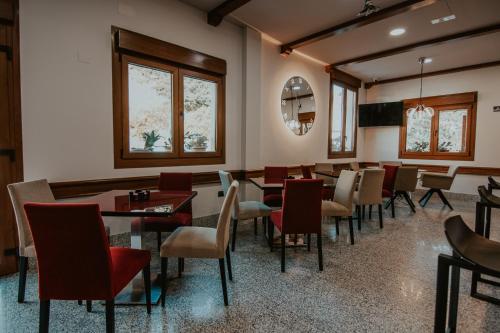 jadalnia ze stołami, krzesłami i oknami w obiekcie Hotel A Veiga w mieście Samos