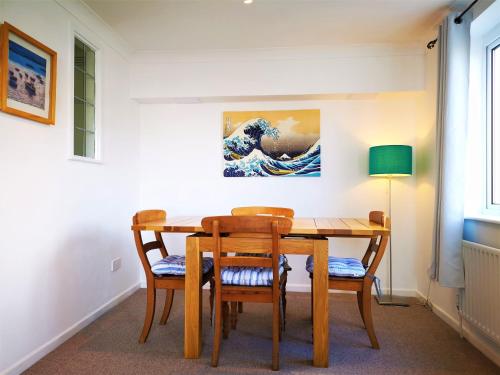 uma mesa de jantar e cadeiras com um quadro na parede em Marina living with parking, balcony, quiet and secure em Brighton & Hove