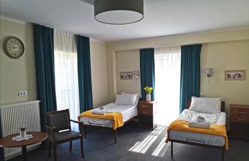 een hotelkamer met 2 bedden en een tafel en stoelen bij Hotel Przy Solankach in Grudziądz