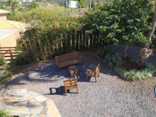 a garden with two benches and a fire hydrant at Terrazzo Suites in Capitólio