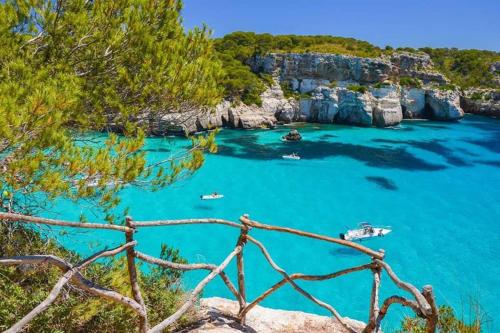 a view of a bay with boats in the water at Miravent Terraza y Jardin Frente al mar Menorca in Fornells