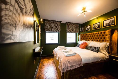a bedroom with a large bed with green walls at Luxury Travel Emporium LS1 - Luxury City Centre Apartments in Leeds