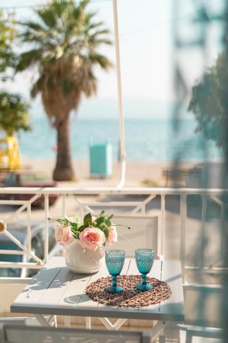 a table with two vases and a vase with flowers at Seaside Apartments in Áyios Vasílios