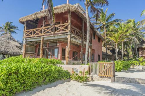 a house under construction with palm trees in front of it at La Conchita Tulum in Tulum