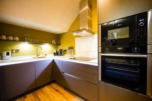cocina con fregadero y microondas en Maison Parfaite LS1 - Luxury City Centre Suites en Leeds