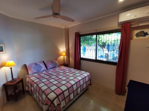a small bedroom with a bed and a window at Magayon Pink House in Legazpi