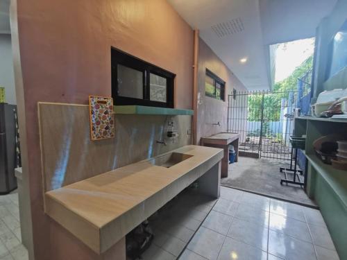 a kitchen with a large sink in a room at Magayon Pink House in Legazpi