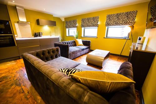 uma sala de estar com um sofá e uma cozinha em Maison Parfaite LS1 - Luxury City Centre Suites em Leeds