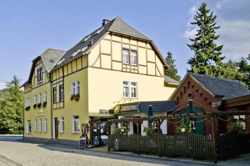 a large yellow building with a shop in front of it at Land-gut-Hotel Cafe Meier in Kurort Oybin