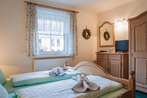 a bedroom with a bed with towels on it at Land-gut-Hotel Cafe Meier in Kurort Oybin