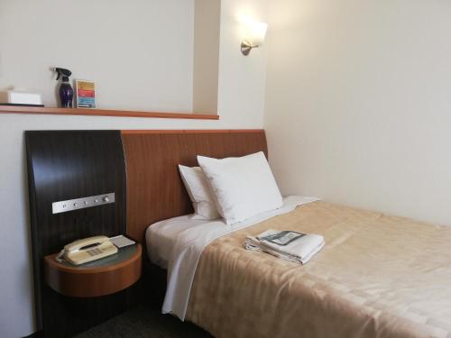 a hotel room with a bed and a table with towels at GRG Hotel Naha Higashimachi in Naha