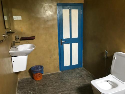 カルタラにあるVilla Whispering Shellsの青いドアとシンク付きのバスルーム