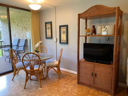 a living room with a television and a table and chairs at Perfect for families and couples - Maui Sunset A-203 in Kihei