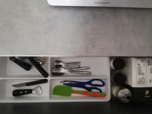 a plastic container with scissors and other kitchen utensils at Apartment HOLIDAY HOUSE in Sukko