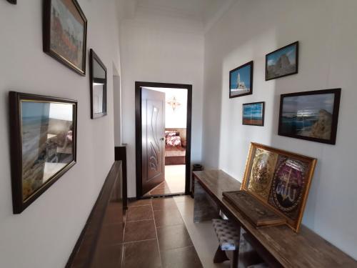 un pasillo con una puerta y cuadros en las paredes en BESQALA, en Nukus