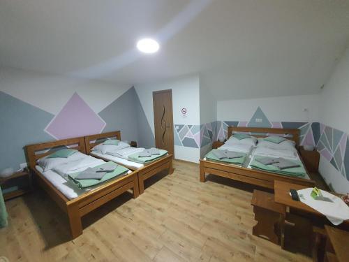 Habitación con suelo de madera y 2 camas. en Air&Day, en Vecsés