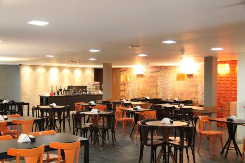a dining room filled with tables and chairs at Vista Inn Express Contagem in Contagem