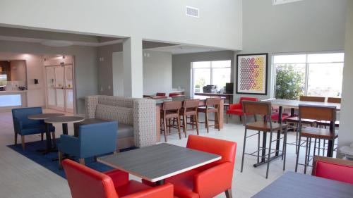 a dining room with tables and chairs and windows at Holiday Inn Express Hotel & Suites Somerset Central by IHG in Somerset