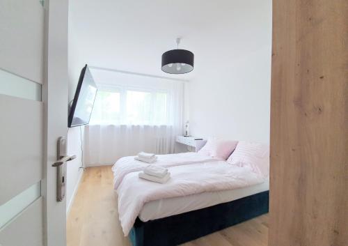 1 dormitorio con 1 cama con sábanas blancas y ventana en Brzeźno Park - Rodzinny Gdańsk Plaża en Gdansk