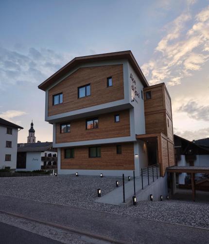 a brown and white building on the side of a street at Alpe di Susi in Castelrotto