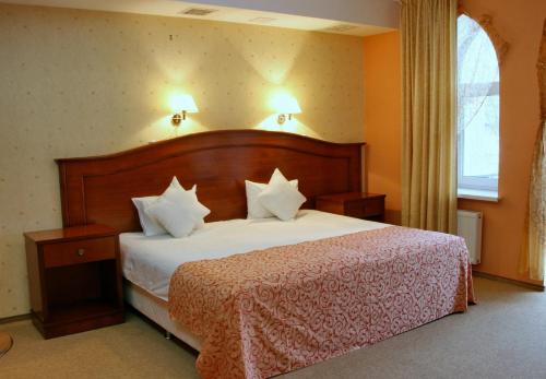 a bedroom with a large bed with white pillows at Premier Hotel Shafran in Sumy