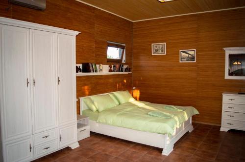 1 dormitorio con 1 cama y pared de madera en FONTREY, en Fontanka