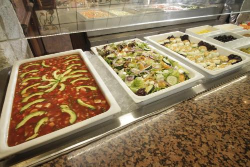 a buffet with three trays of different types of food at Holiday Inn Queretaro Centro Historico by IHG in Querétaro