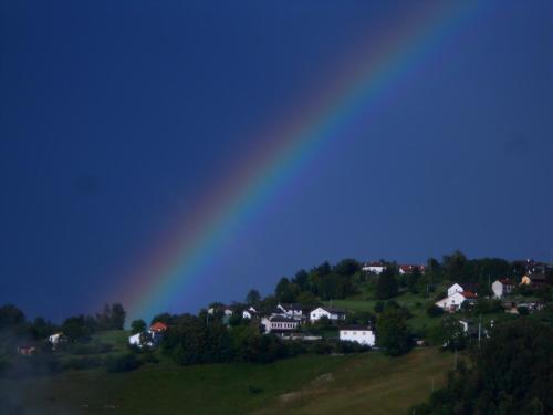a rainbow over a town with houses on a hill at Agriturismo La Casa Nei Boschi in Colderù