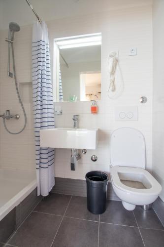 a white bathroom with a sink and a toilet at Plaza 1 in Sveti Juraj