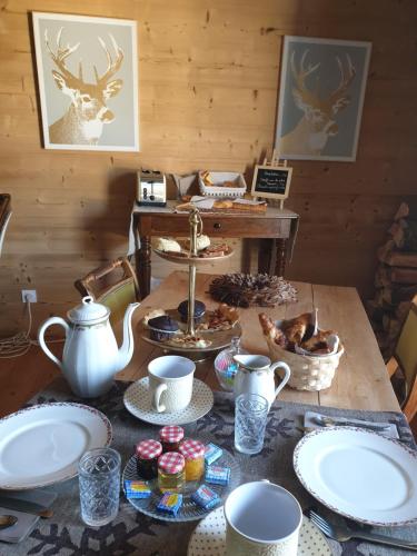 a table with plates and cups and food on it at La Petite Chapelle in Font-Romeu