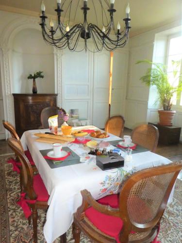 a dining room with a table with chairs and a chandelier at Domaine de Seugnac in Pons