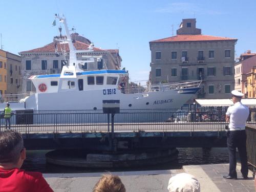 a man standing next to a boat in the water at Hotel Clodia in Chioggia