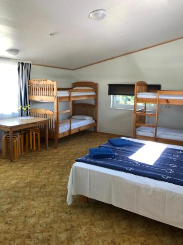 een slaapkamer met een bed, een tafel en een stapelbed bij Kipperi Turismitalu in Saulepa