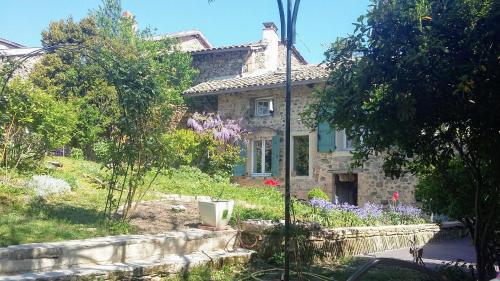 una casa de piedra en medio de un jardín en Domaine de la Fée-Licité, en Jullié