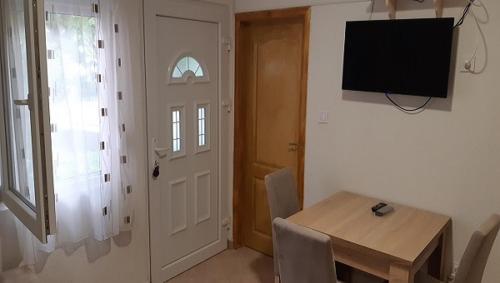 a dining room with a table and a television and a door at Apartment Sali in Kotor