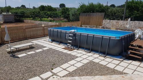 a large swimming pool in a yard with a fence at I Trulli Di Nonno Giovanni in Martina Franca